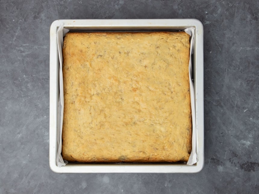 same square metal pan with light yellow cake baked